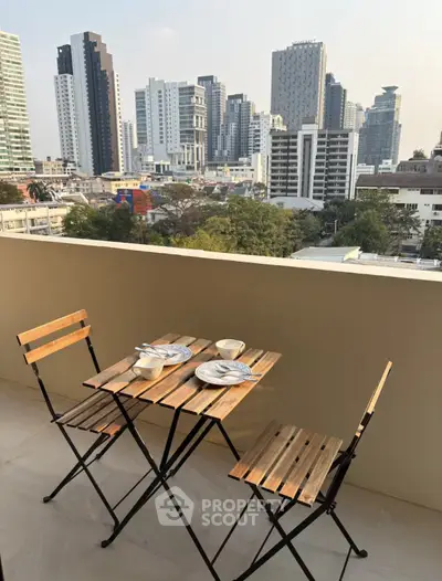 Charming balcony with city skyline view, perfect for relaxing and dining outdoors.