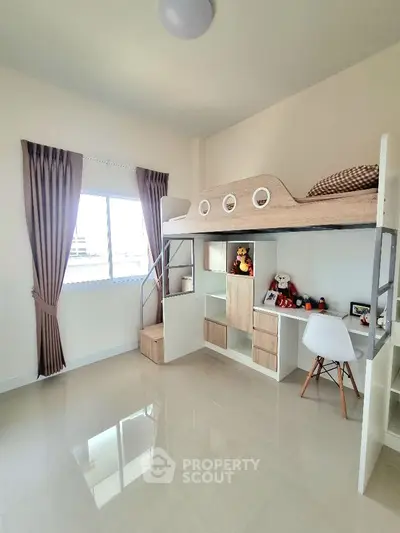 Modern bedroom with loft bed and study area, featuring sleek design and ample natural light.