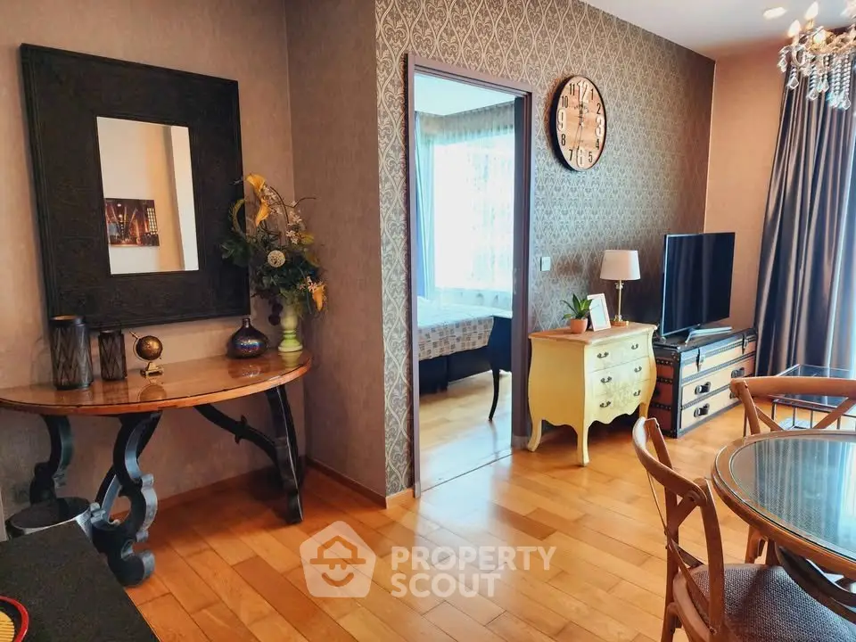 Charming living room with elegant decor and wooden flooring, featuring a stylish TV setup and dining area.