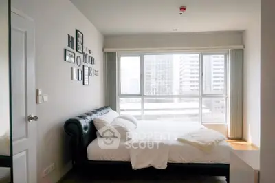 Modern bedroom with large window and city view in high-rise apartment