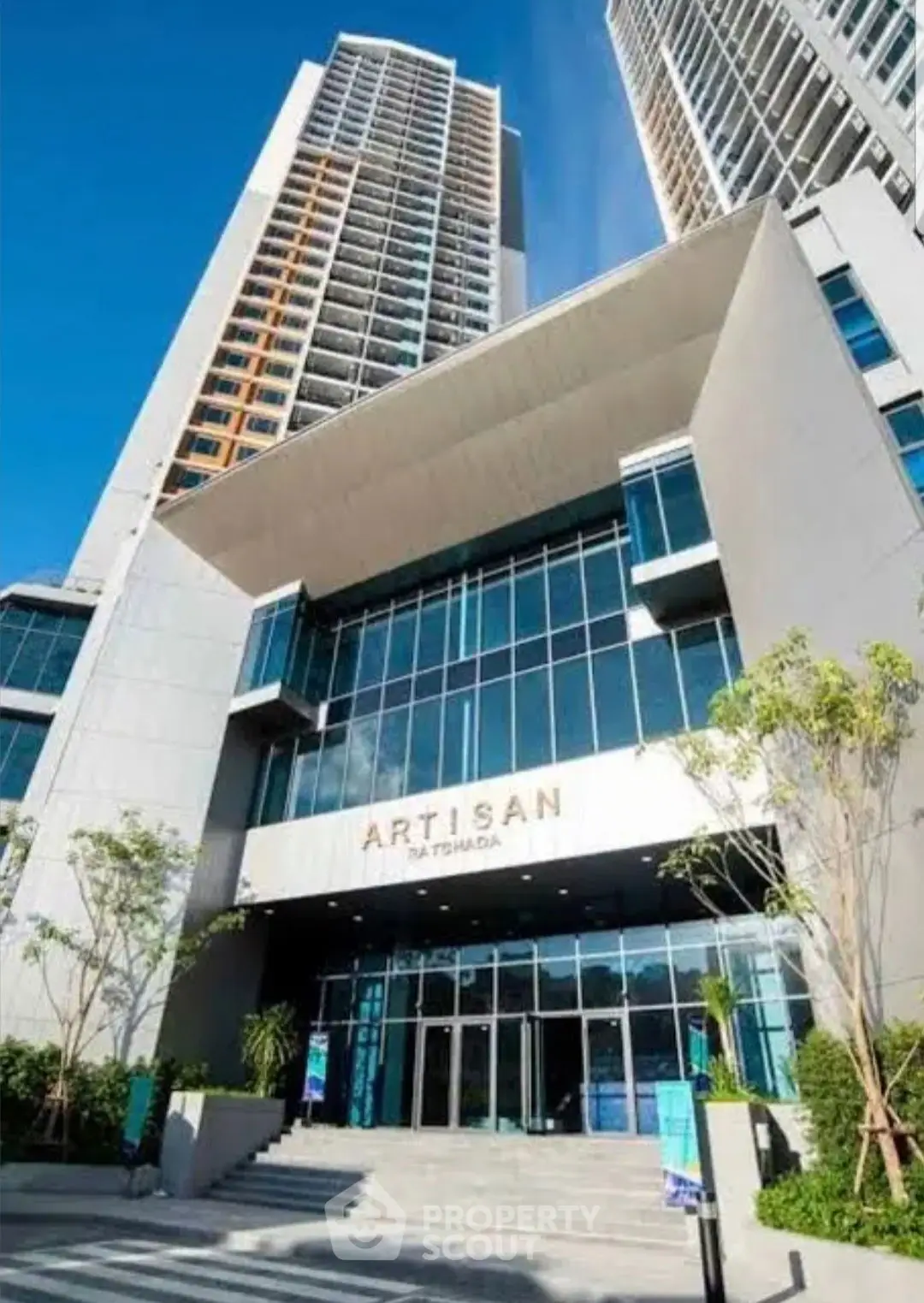 Stunning modern high-rise building with sleek architecture and lush landscaping.