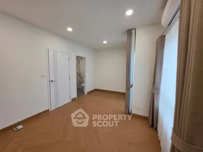 Spacious bedroom with elegant wood flooring and ample natural light