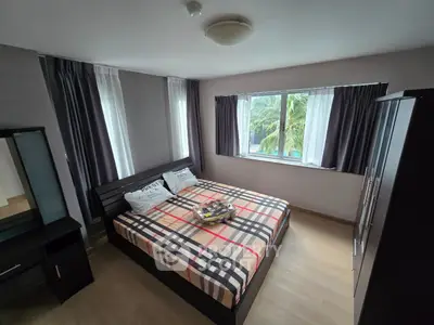 Cozy bedroom with modern decor and large window offering lush garden view