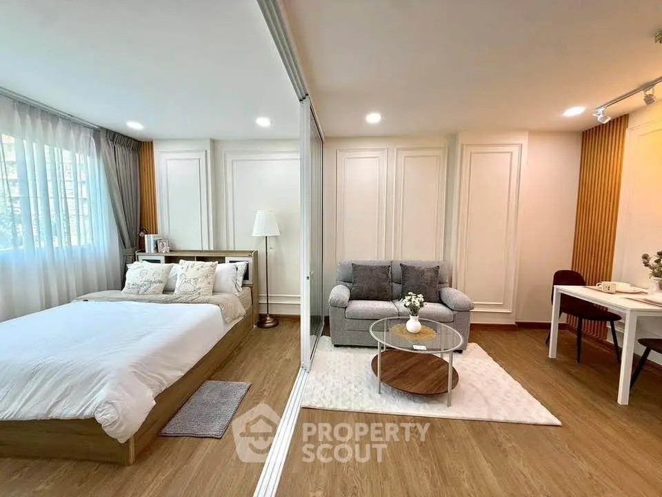 Modern studio apartment with cozy bedroom and stylish living area, featuring elegant decor and natural light.