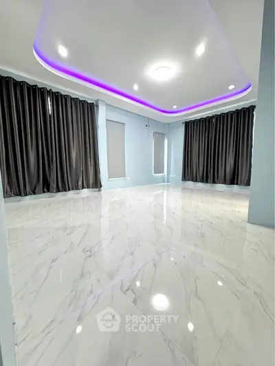 Spacious modern living room with elegant marble flooring and ambient LED ceiling lights.