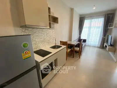 Modern open-layout kitchen and living room with natural light and stylish furnishings.