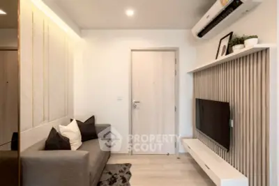 Modern living room with sleek design, featuring a cozy sofa, wall-mounted TV, and stylish decor.