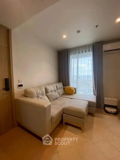 Cozy living room with modern sofa and city view through large window, perfect for relaxation.