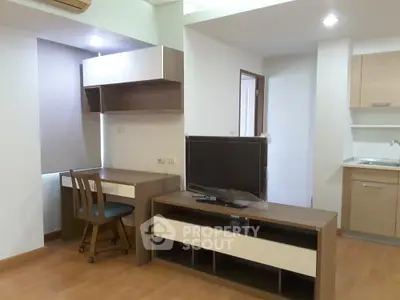 Modern apartment interior with study area and TV unit, featuring wooden flooring and contemporary design.