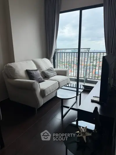 Modern living room with cozy sofa and stunning city view from balcony.