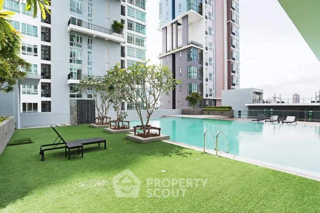 Luxurious modern apartment complex with stunning pool and lush greenery.