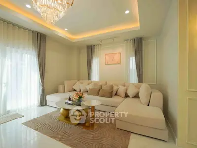 Luxurious living room with elegant chandelier and plush sectional sofa in a modern home.