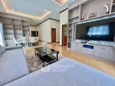 Spacious modern living room with elegant dining area and large TV, perfect for family gatherings.