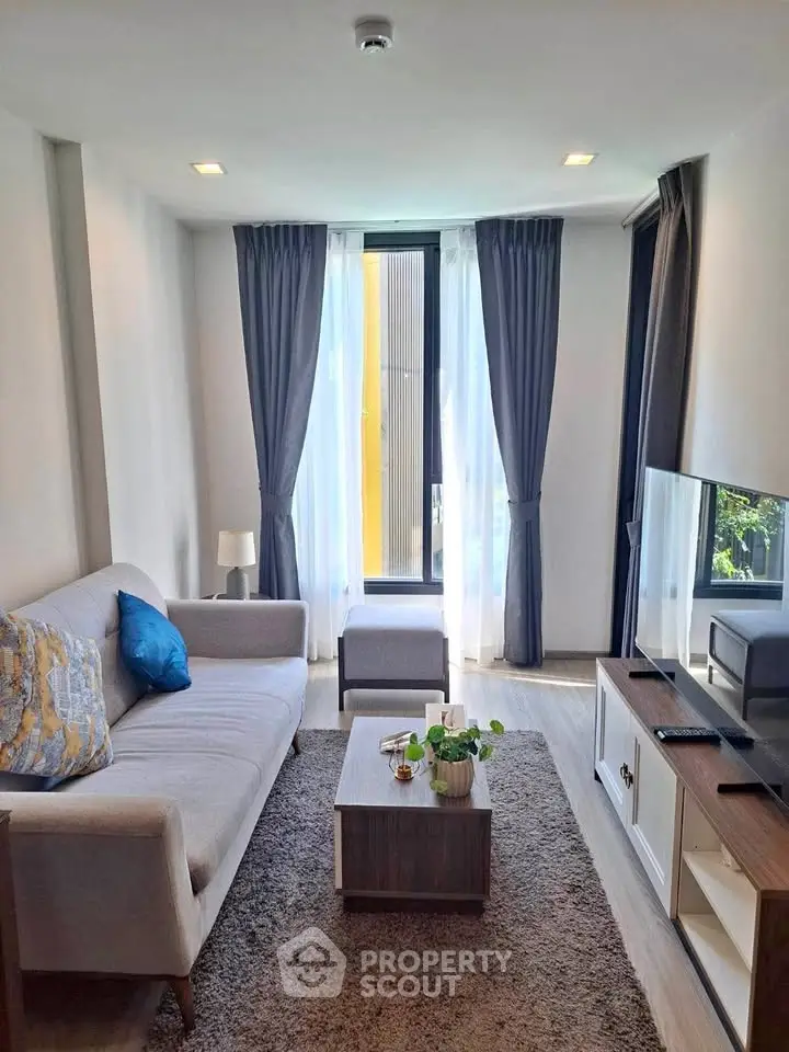 Modern living room with cozy sofa and large window, perfect for relaxation.