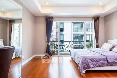 Spacious bedroom with elegant decor and large windows offering a city view.