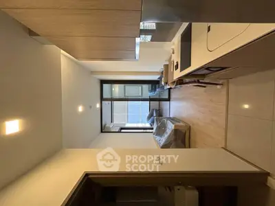 Modern studio apartment with open layout and sleek design, featuring a cozy living area and large windows.