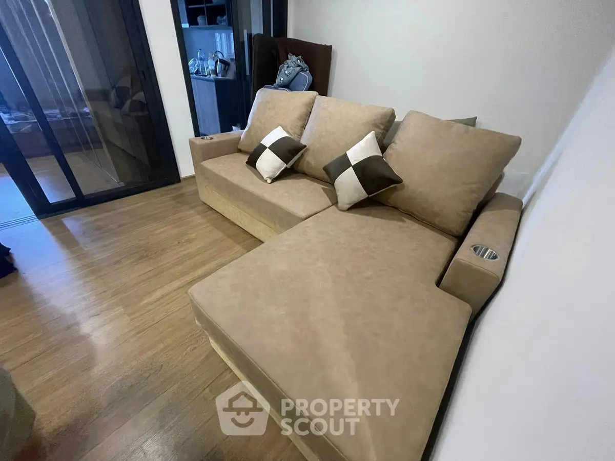 Modern living room with stylish beige sectional sofa and wooden flooring