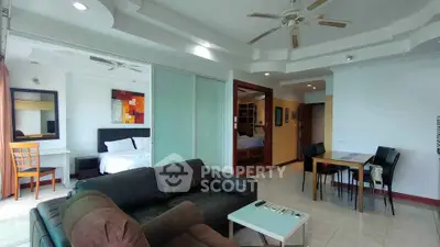 Spacious living room with modern decor and adjacent bedroom in open layout apartment.