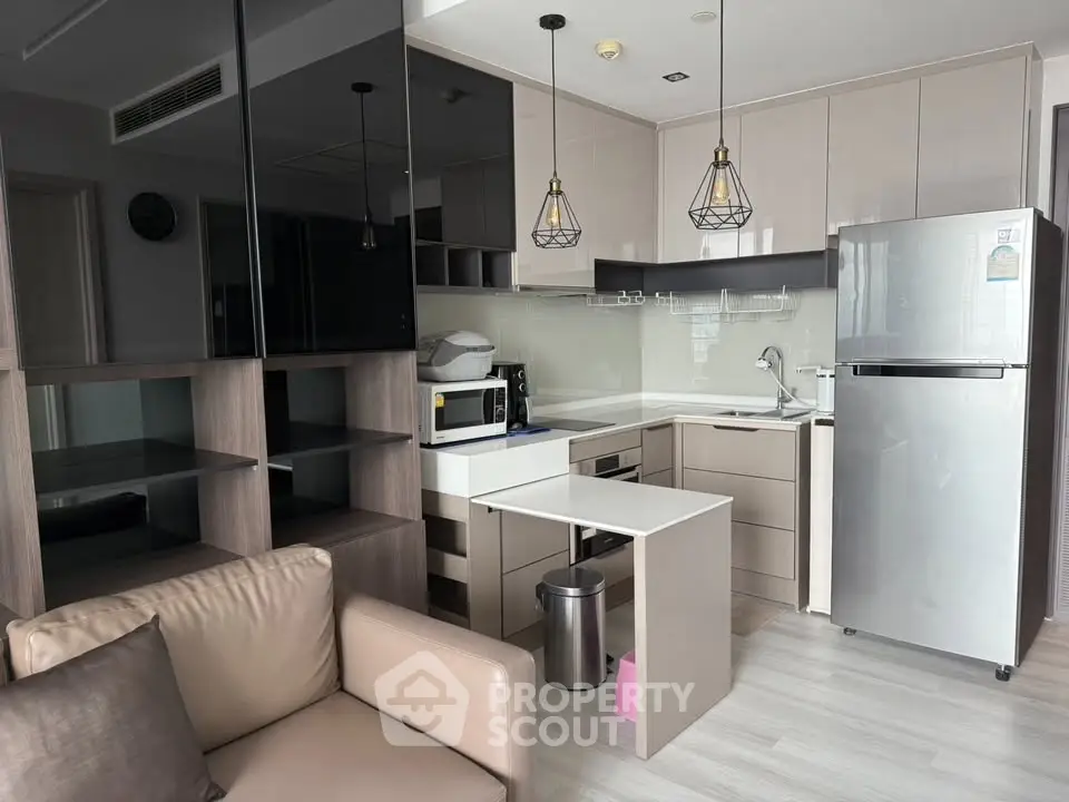Modern kitchen with sleek cabinetry and stainless steel appliances in a stylish apartment.