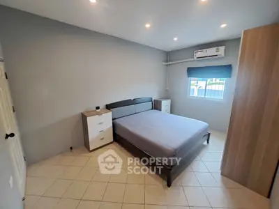 Cozy bedroom with modern furnishings and air conditioning in a well-lit space.