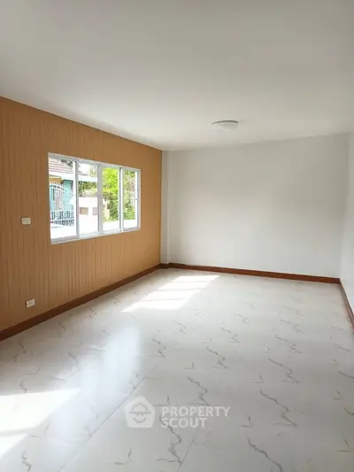 Spacious empty room with large window and marble floor tiles