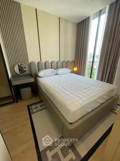 Modern bedroom with stylish decor and large window offering city views