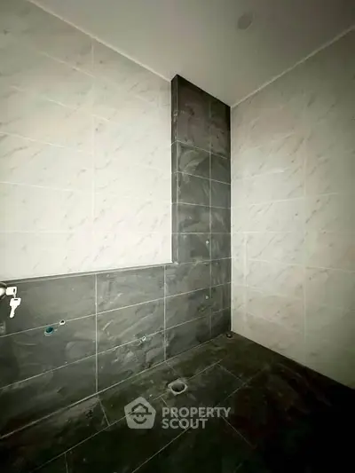 Modern bathroom with sleek dark tiles and elegant marble accents.