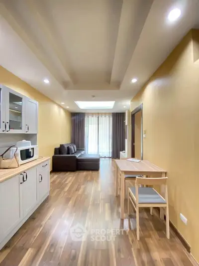 Spacious living room with modern decor and wooden flooring, featuring a cozy seating area and dining space.