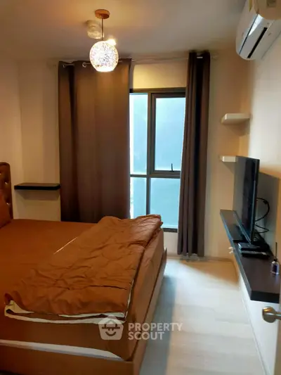 Cozy bedroom with modern decor, featuring a comfortable bed, wall-mounted TV, and air conditioning.