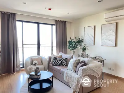 Stylish living room with cozy sofa, modern decor, and large windows offering natural light.