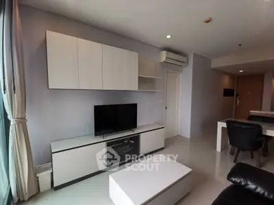 Modern living room with sleek furniture and natural light, perfect for relaxation and entertainment.