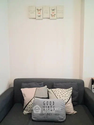 Cozy living room with stylish gray sofa and decorative pillows, perfect for relaxation.