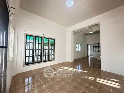 Spacious tiled living area with large windows and natural light