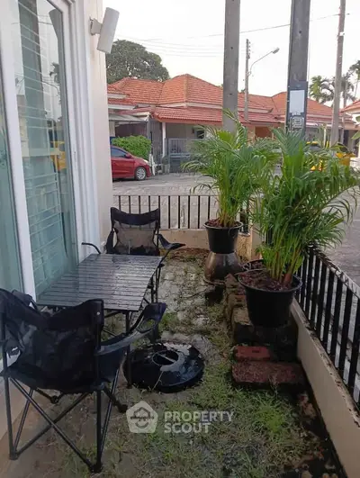 Charming small patio with outdoor seating and potted plants, perfect for relaxation.