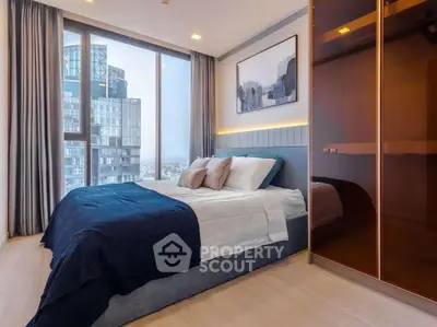 Luxurious bedroom with floor-to-ceiling windows and city view in modern high-rise apartment.