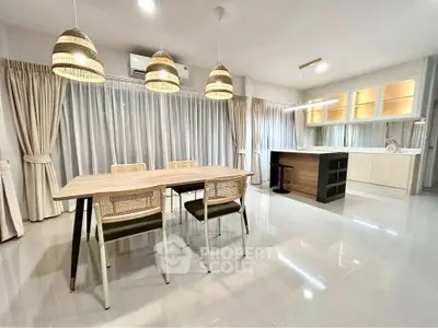 Spacious modern dining area with elegant lighting and open kitchen layout