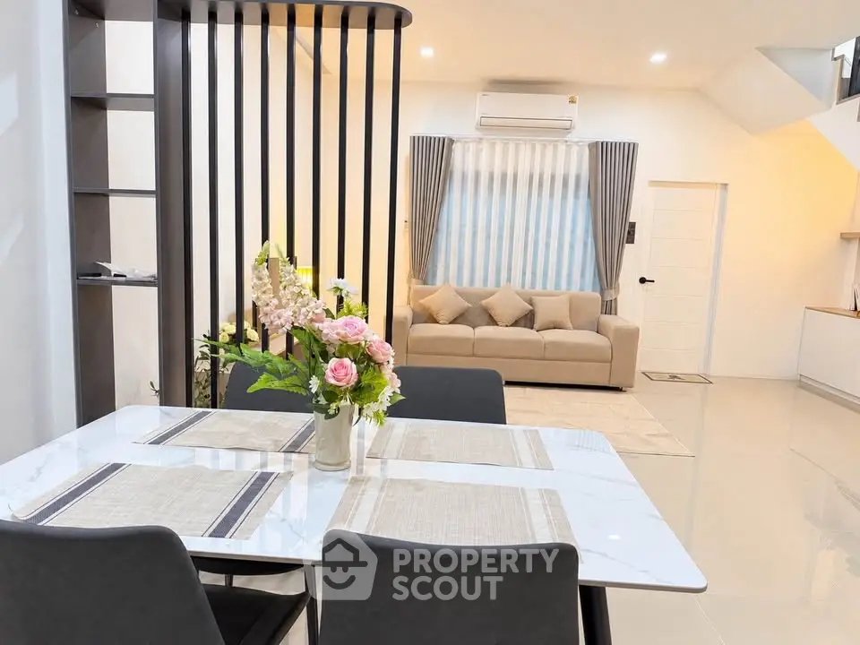 Modern open-plan living and dining area with elegant decor and natural light.