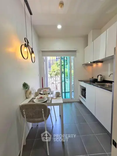 Modern kitchen with sleek design, open layout, and balcony view, perfect for urban living.