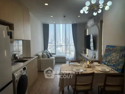 Modern living room with dining area, featuring stylish decor and large window with city view.