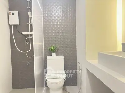 Modern bathroom with sleek design and stylish fixtures, featuring a shower and toilet.