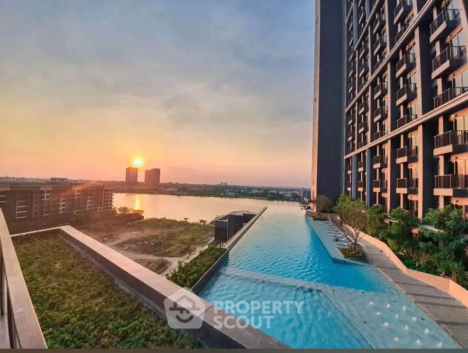 Stunning sunset view from luxury apartment with infinity pool and lush greenery.