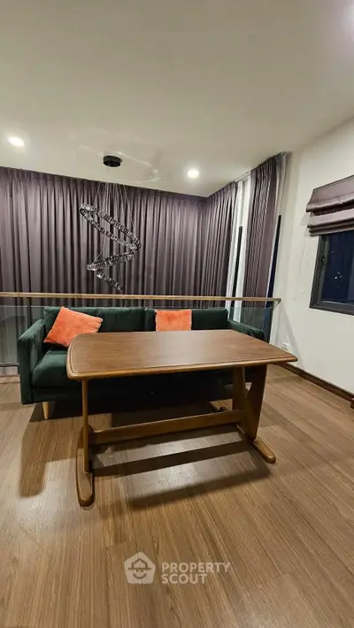 Modern living room with stylish sofa and wooden table, featuring elegant lighting and floor-to-ceiling curtains.