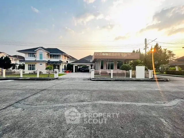 Charming suburban homes with spacious driveways and manicured lawns at sunset.