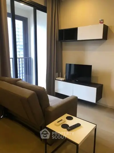Modern living room with sleek furniture and balcony view in urban apartment