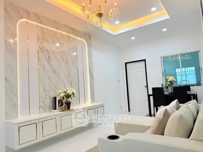 Luxurious living room with elegant chandelier and modern marble wall design.