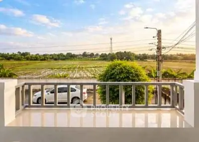 Charming balcony with serene countryside view and ample sunlight.