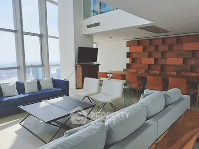 Luxurious modern living room with stunning city view, featuring stylish furniture and floor-to-ceiling windows.