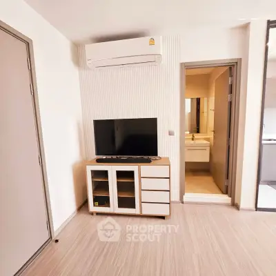 Modern apartment interior with air conditioning and TV unit, showcasing a sleek bathroom entrance.