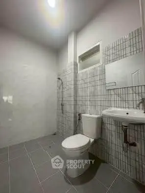 Modern bathroom with sleek tiles and contemporary fixtures.