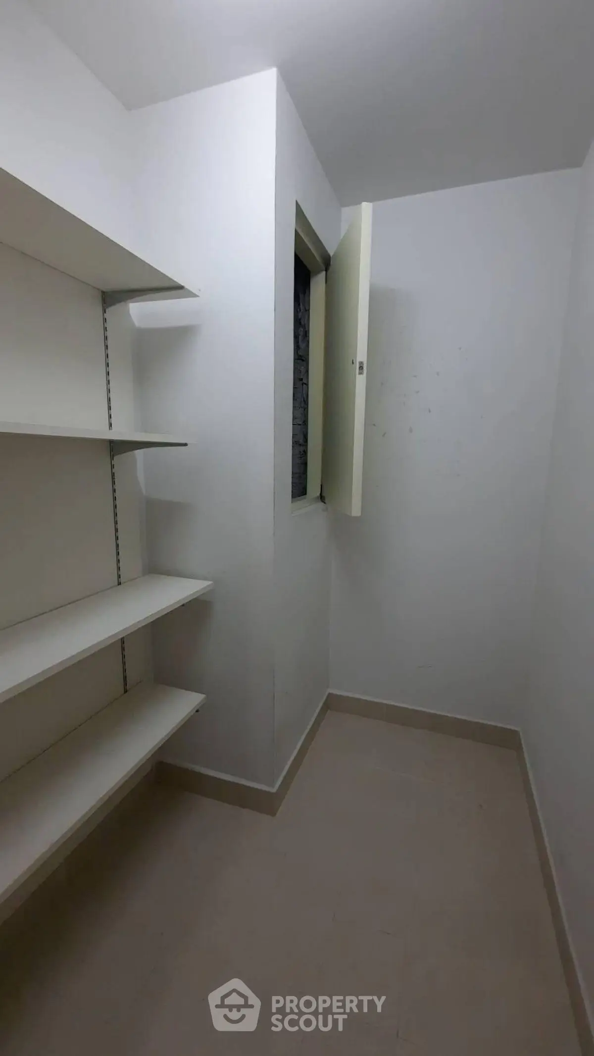 Spacious storage room with built-in shelves and natural light.